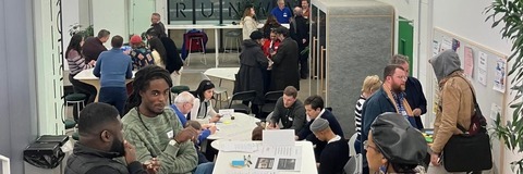 Residents and attendees in conversation across different breakout tables
