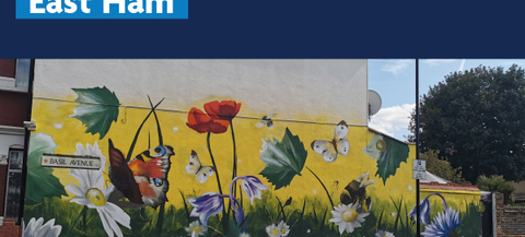The image shows a mural painted on the side of a building. The mural features various flowers, butterflies, and a large butterfly with red and black wings. There is also a street sign that reads "Basil Avenue." The top part of the image contains text that says "People Powered East Ham" and includes the logo for Newham London.