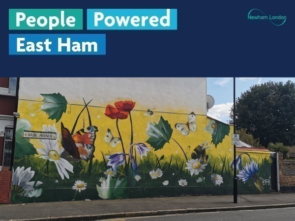 The image shows a mural painted on the side of a building. The mural features various flowers, butterflies, and a large butterfly with red and black wings. There is also a street sign that reads "Basil Avenue." The top part of the image contains text that says "People Powered East Ham" and includes the logo for Newham London.