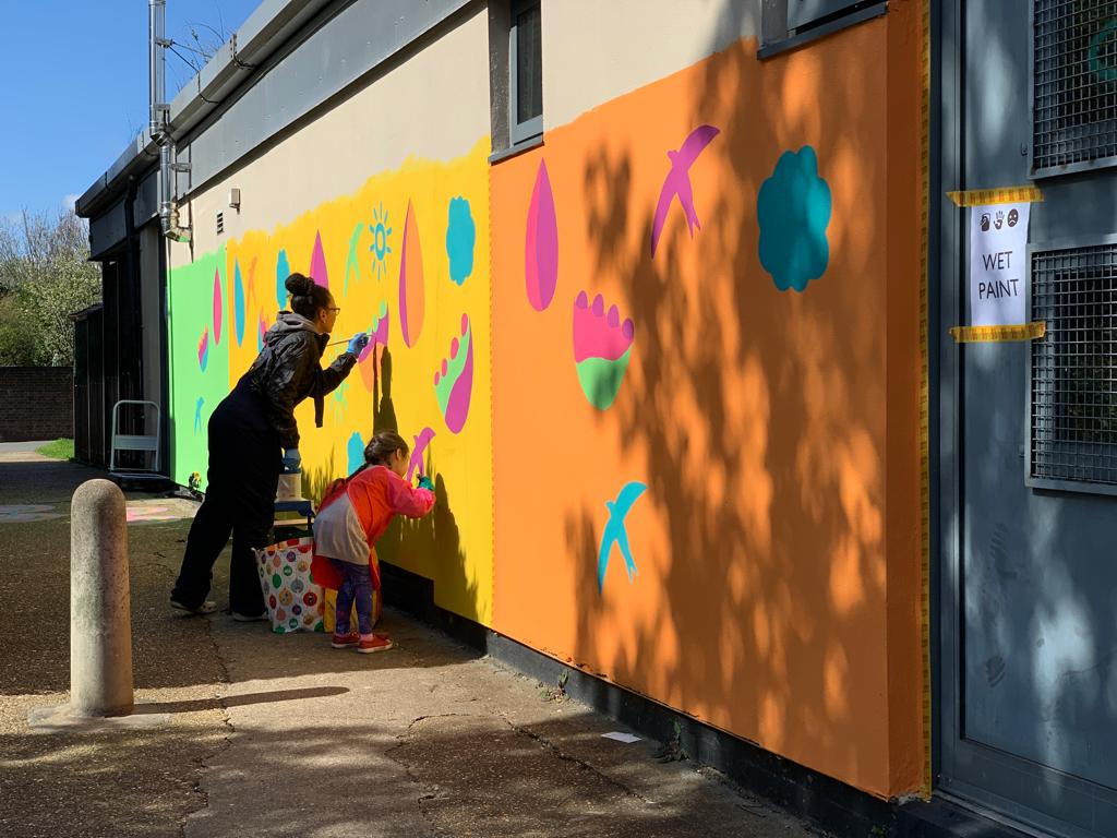 Nursery wall mural – Antonietta and a young local resident volunteer (also an alumnus of Little Diamonds nursery) painting the design: