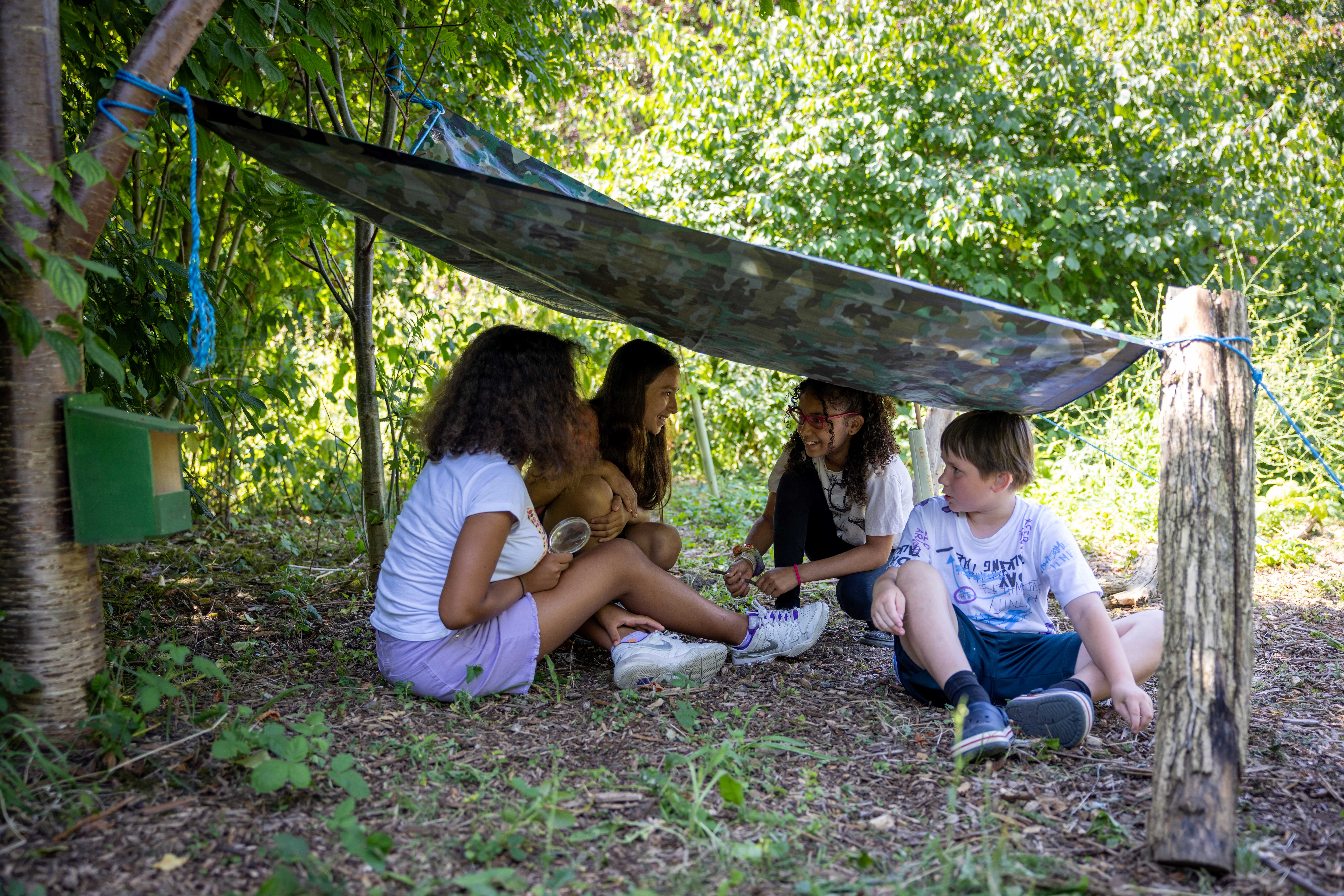 Children laughing under a canopy outside