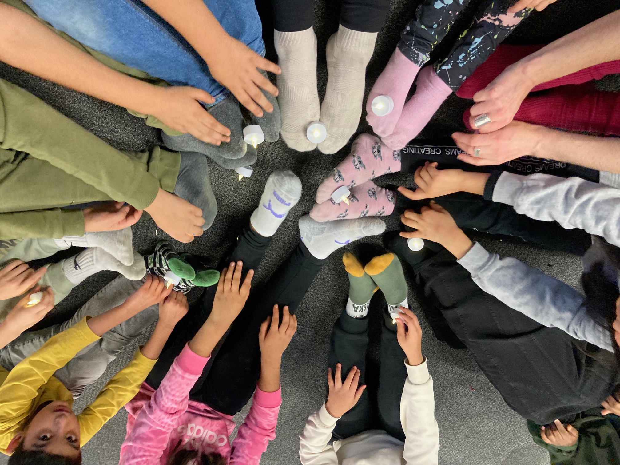 Young participants stretching to reach tea-light