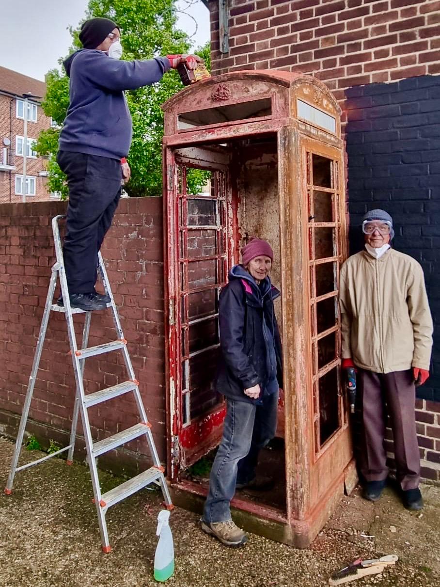 volunteers renovating the phone box