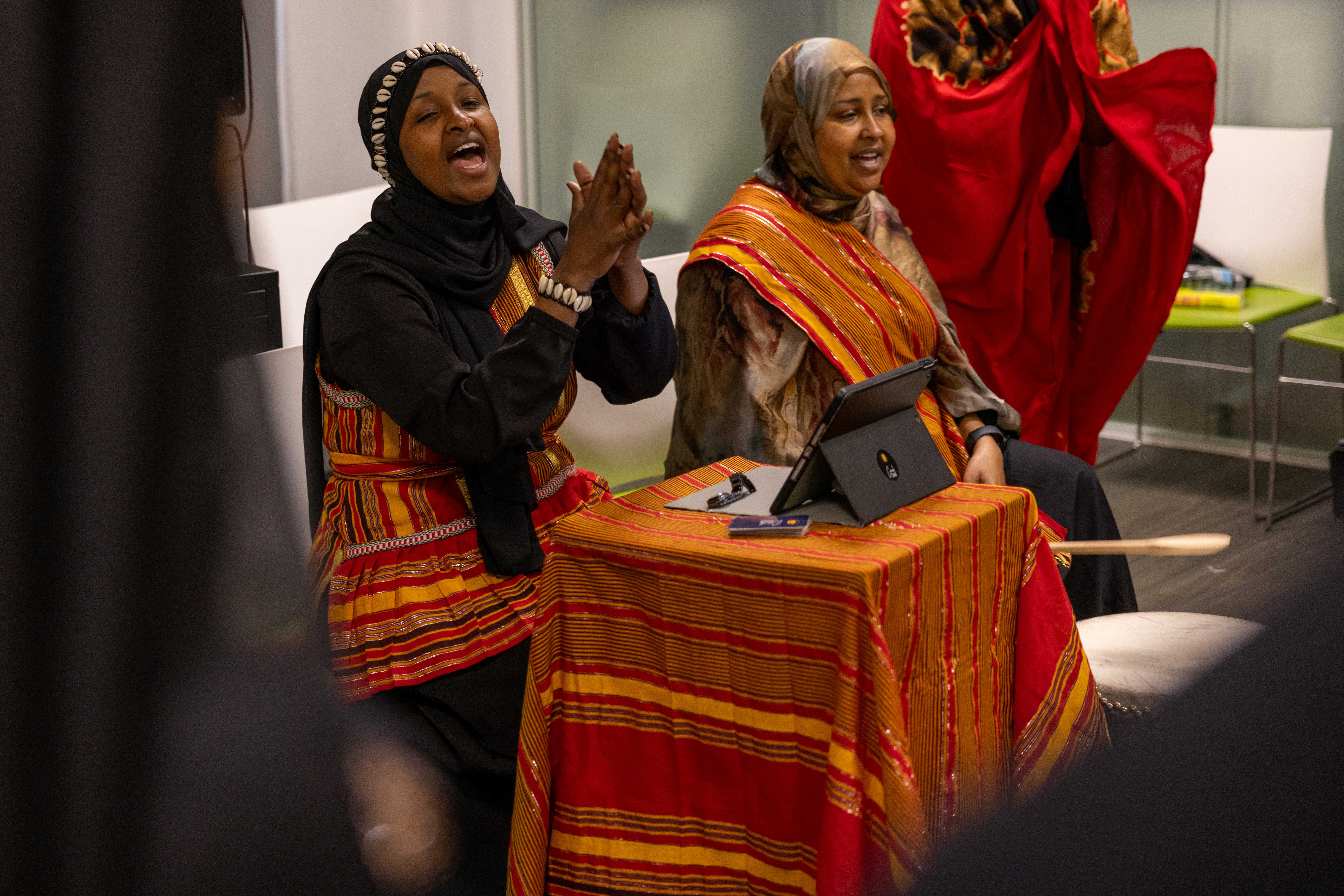 Two ladies singing. One lady clapping