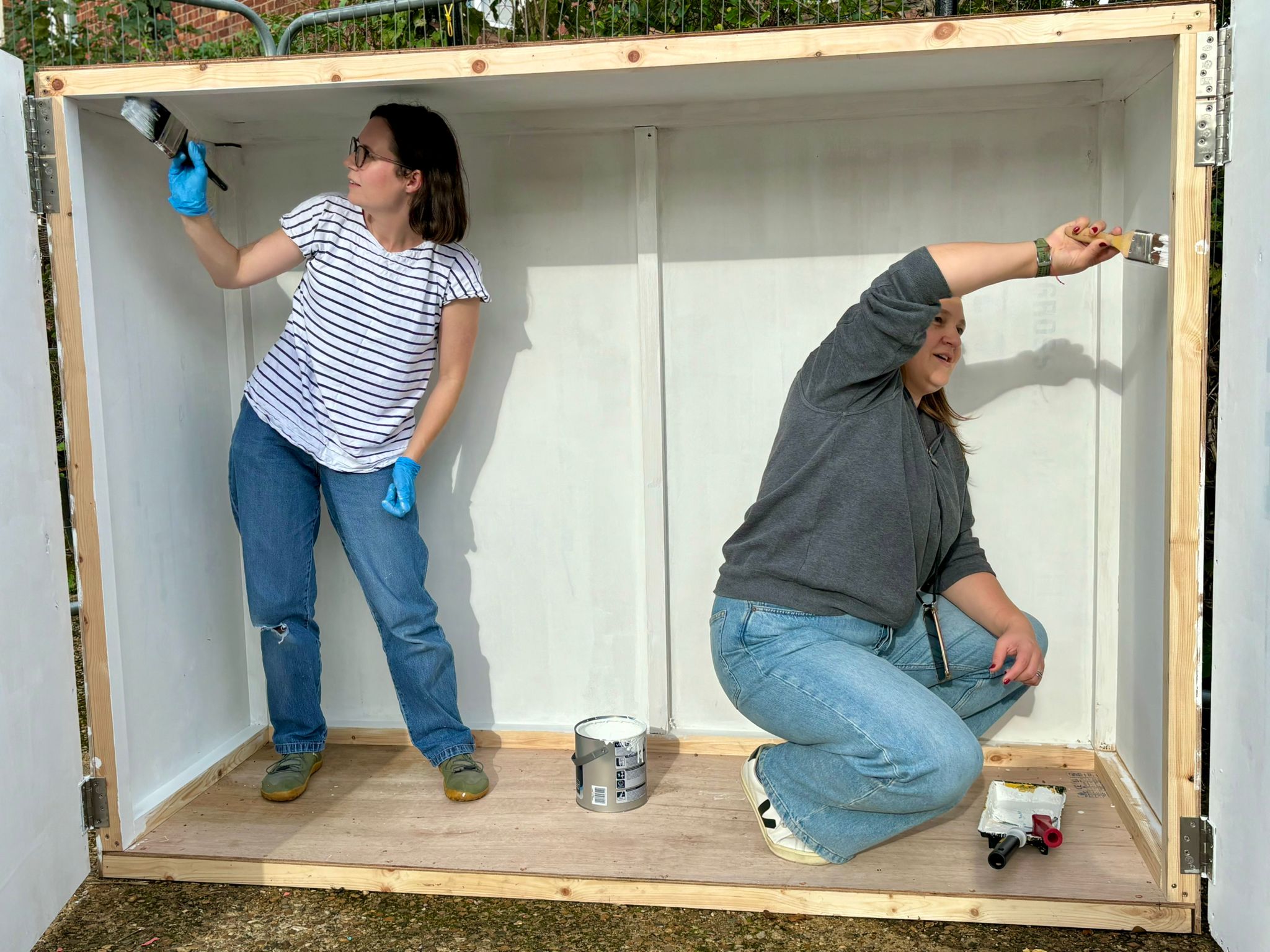 volunteers painting the weatherproof cabinet for the piano
